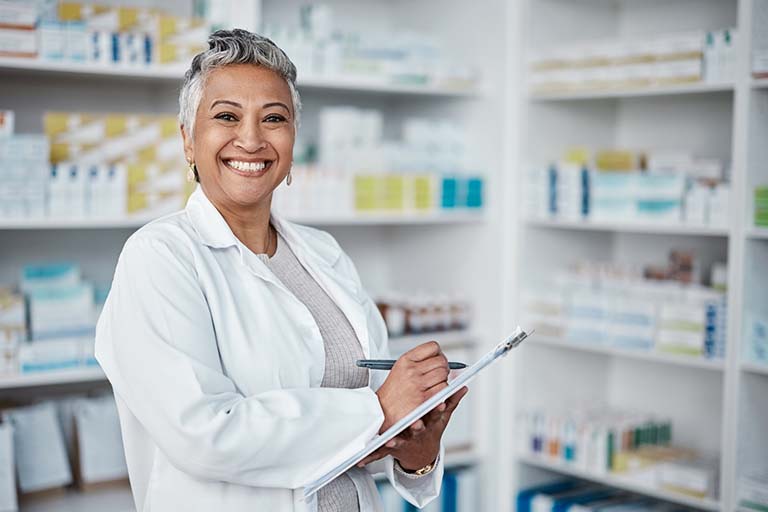 Pharmacist at a pharmacy holding a clipboard.