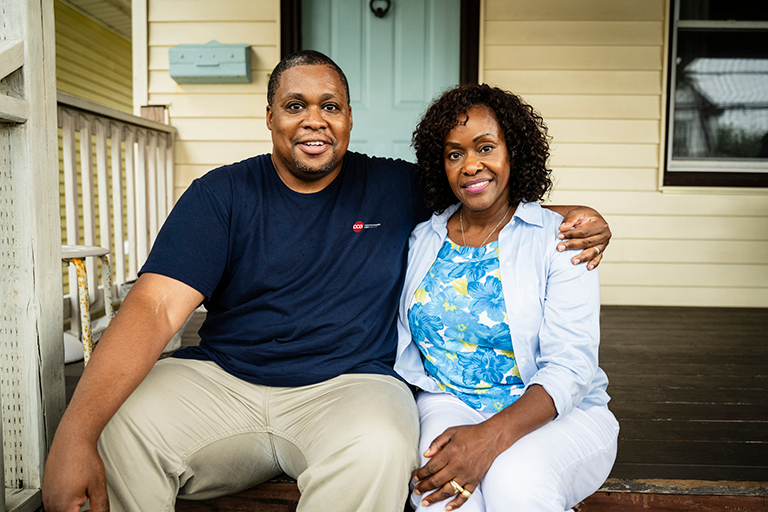 CCA care partner and CCA member sitting outside the member's home on her poarch.